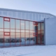 Das Bild zeigt das Gebäude unseres Rechenzentrums in Island - eine große, hohe Halle, deren verglaste Fassade den Bildmittelpunkt bildet. Was sich im Inneren dieses Rechenzentrums abspielt und wie ein Rechenzentrum funktioniert, erfährst du in unserem neuen Blogbeitrag.