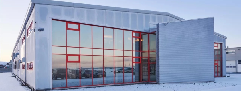 Das Bild zeigt das Gebäude unseres Rechenzentrums in Island - eine große, hohe Halle, deren verglaste Fassade den Bildmittelpunkt bildet. Was sich im Inneren dieses Rechenzentrums abspielt und wie ein Rechenzentrum funktioniert, erfährst du in unserem neuen Blogbeitrag.